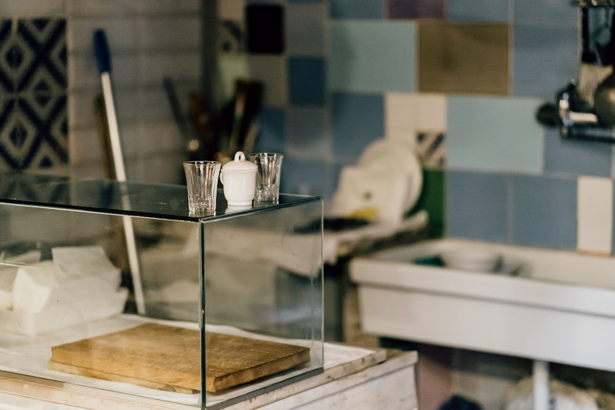 Étagère en verre avec accessoires de cuisine et décoration.