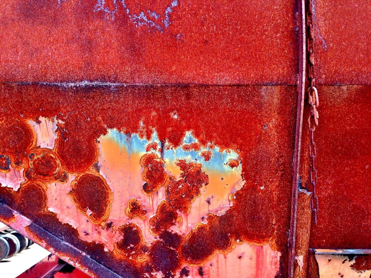 Texture rouillée, motifs irréguliers, couleurs chaudes, détails intéressants, surface métallique.