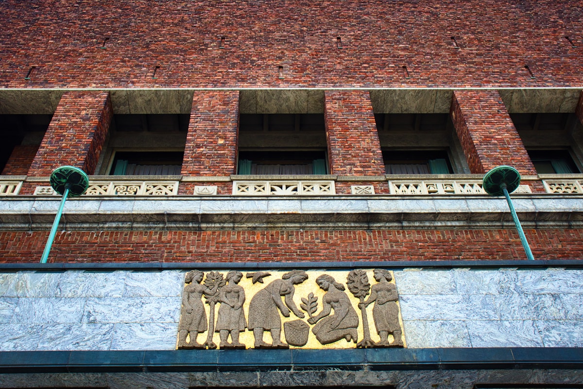 Bâtiment de briques rouges avec détails sculptés en pierre.